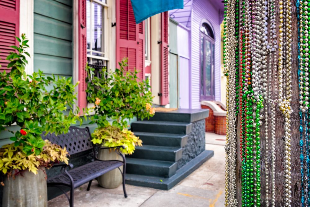 Mardi Gras beads decorate a telephone pole on a New Orleans street of colorful houses